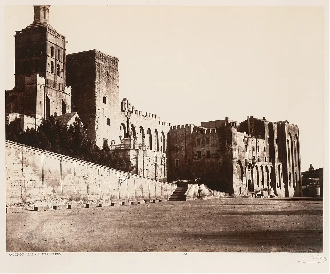 Fotografía sepia de los enormes muros de piedra y las torres cuadradas del Palacio de los Papas de Aviñón, sobre una plaza vacía