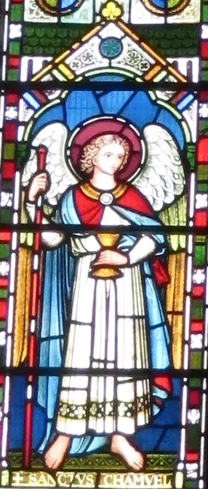 Stained-glass panel of a young haloed angel in a white robe and blue mantle holding a golden chalice and a tall red staff, with the words Sanctus Chamuel below