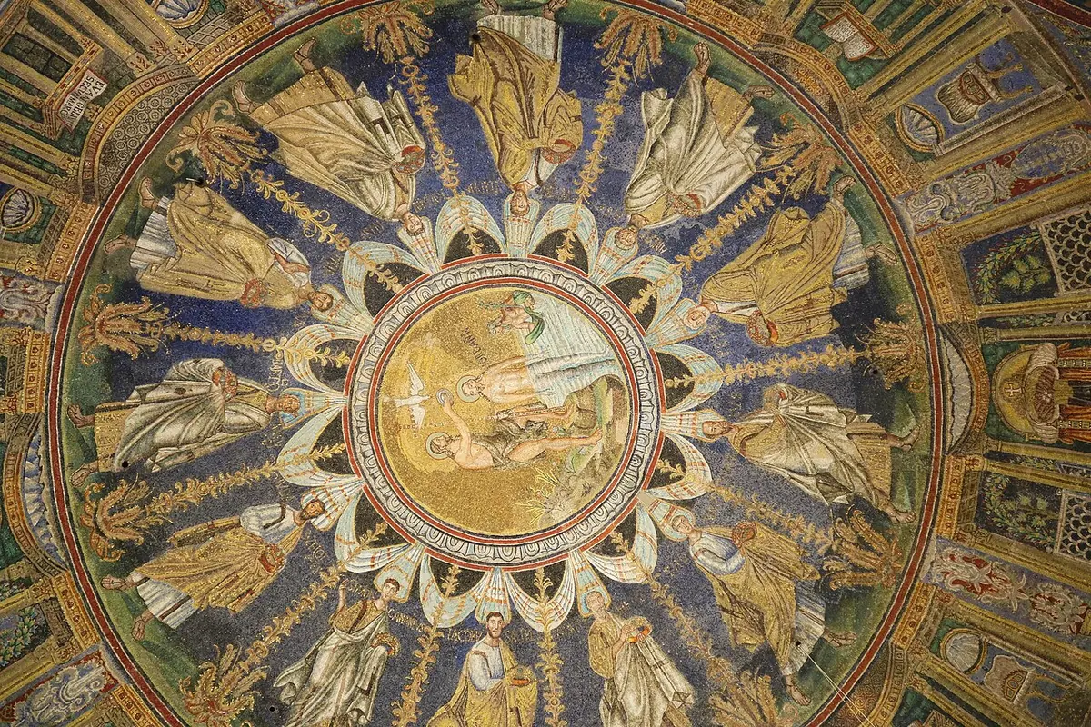 View straight up into a domed ceiling of gold and blue mosaic, with the Baptism of Christ in the central circle and the twelve apostles in white and gold processing around it