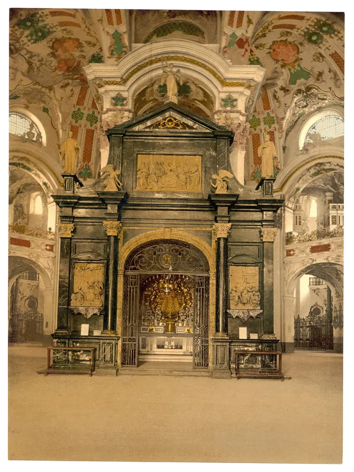 Tinted photograph of a dark marble chapel standing inside a pale Baroque church, with a glowing golden niche in its doorway