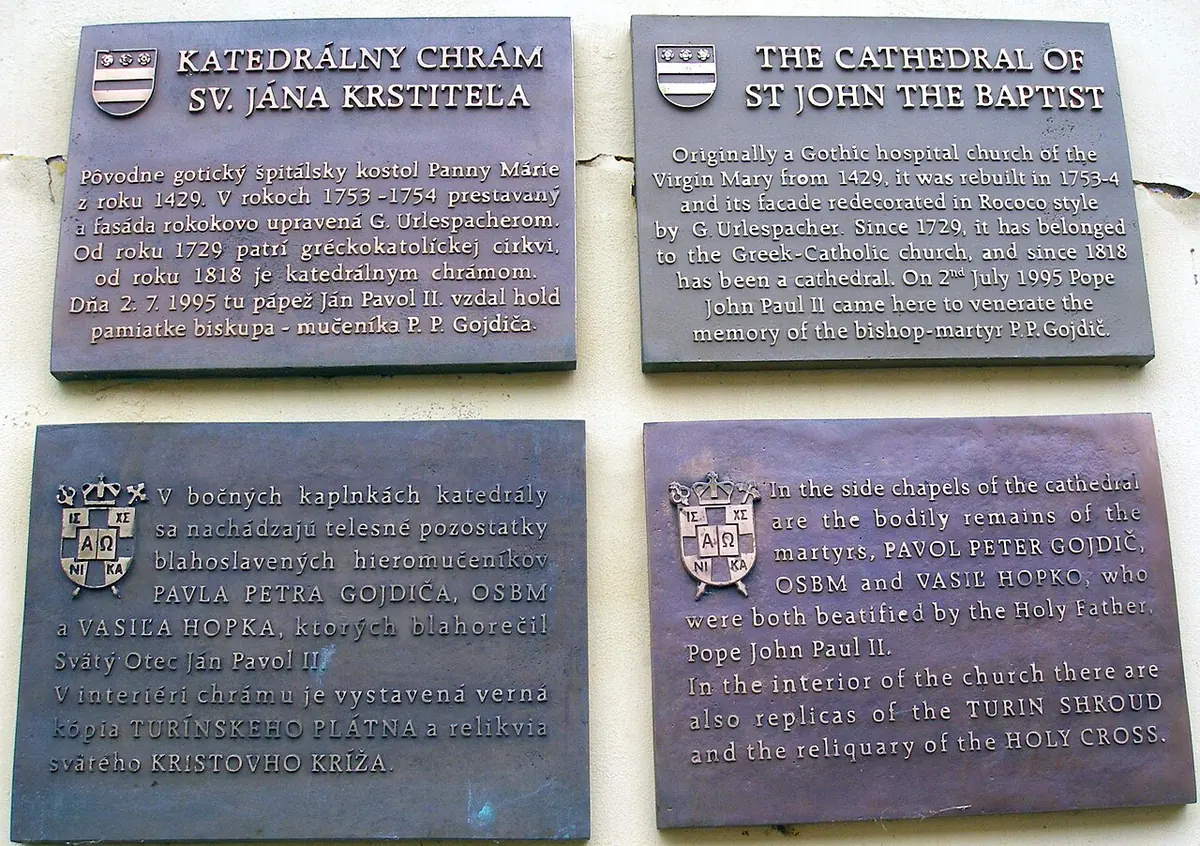 Four bronze plaques in Slovak and English on the cathedral wall, telling its history and naming the martyr bishops Pavol Peter Gojdič and Vasil' Hopko, whose remains rest inside