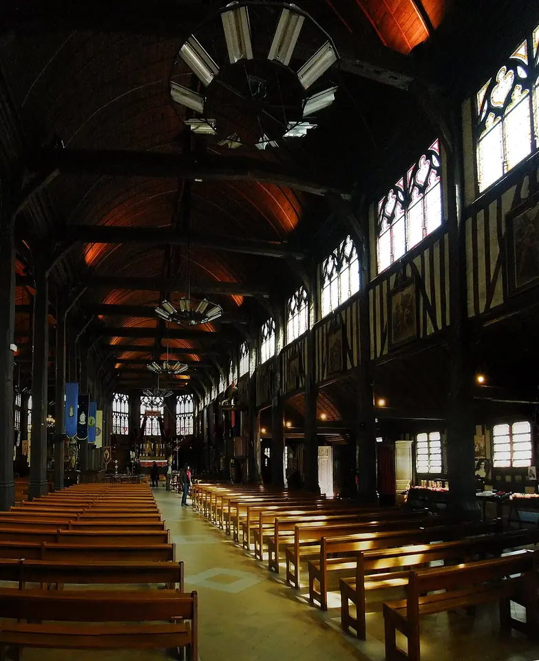 The timber nave of the Church of Sainte-Catherine in Honfleur, with rows of wooden pews under a wooden vault built like a ship's hull turned upside down