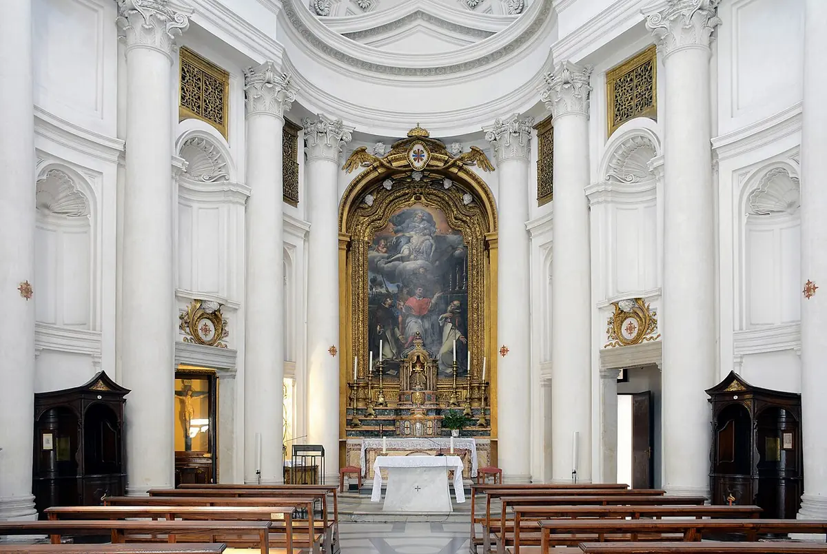 The white oval interior of San Carlino with tall columns, carved niches and a gilded high altar under a painting of the saints before the Holy Trinity