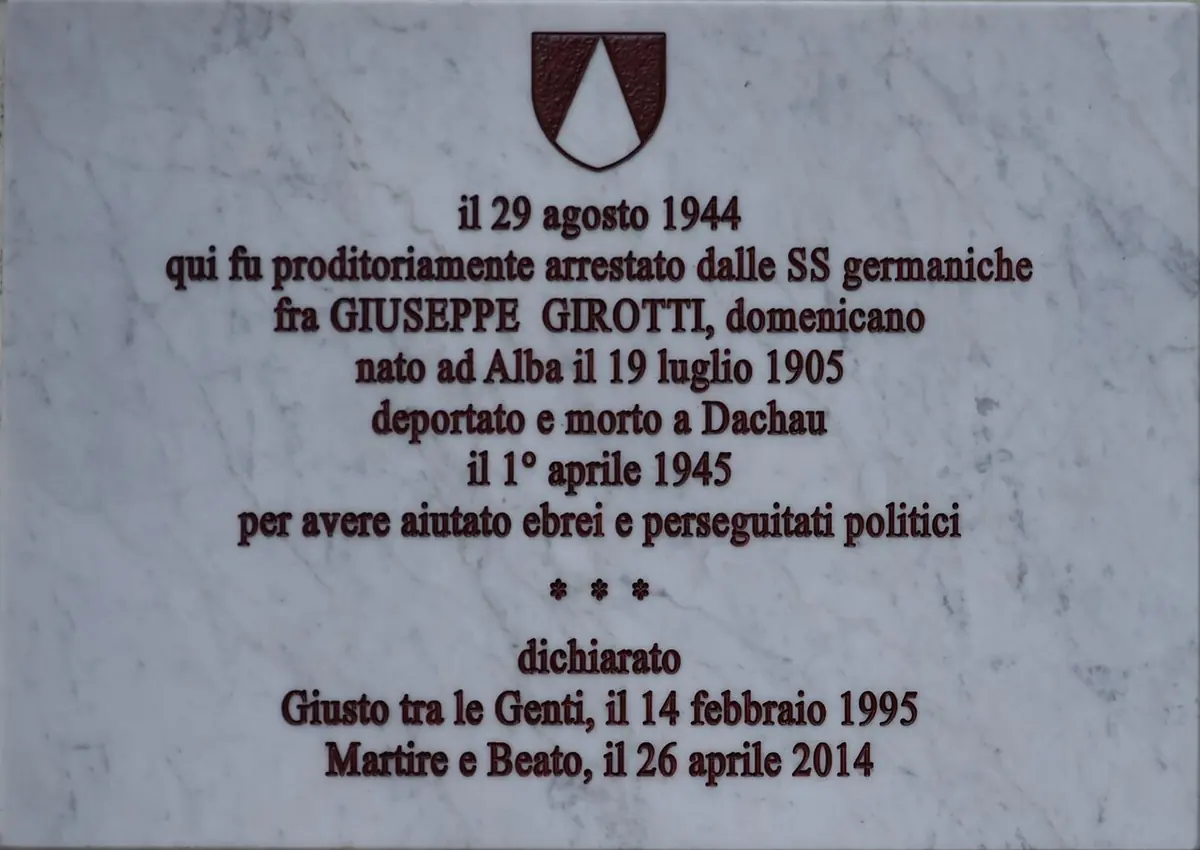 A white marble plaque with a small coat of arms recording that Fr. Giuseppe Girotti was arrested here on August 29, 1944, died at Dachau and was declared Righteous Among the Nations and Blessed