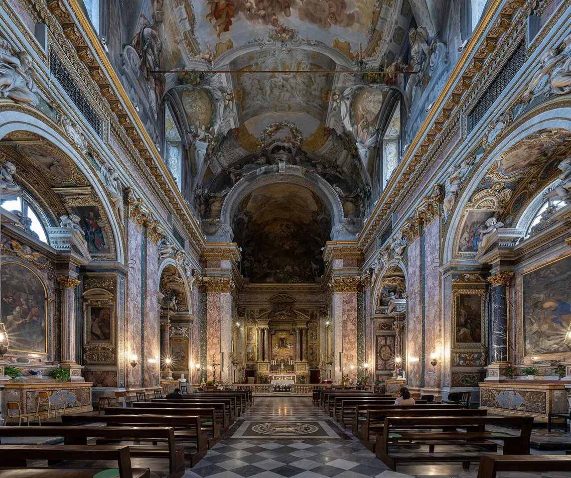 The richly decorated nave of Santi Domenico e Sisto, with a painted vault, marble side chapels and the high altar at the end