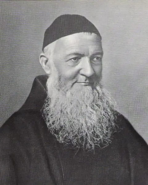 Old black-and-white portrait of an elderly Capuchin friar with a long white beard and a small dark skullcap, smiling slightly