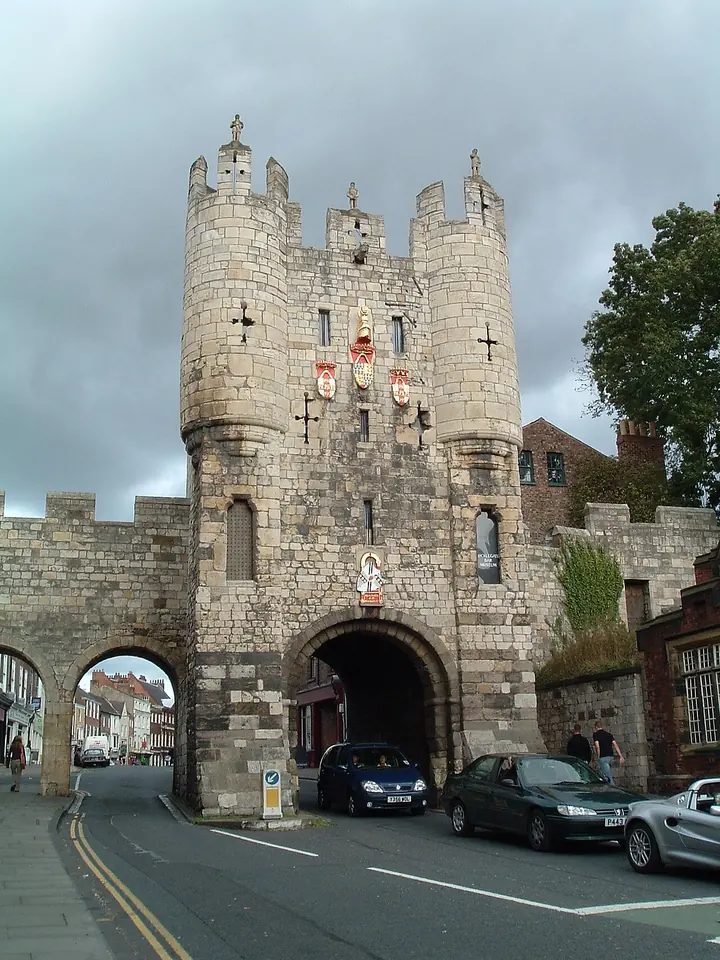 The medieval stone gatehouse of Micklegate Bar in the York city walls, with battlemented turrets and painted coats of arms above the arch