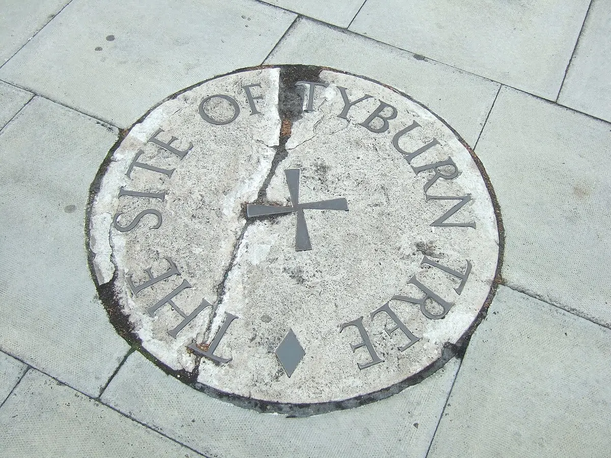 A round stone plaque set into the pavement near Marble Arch, inscribed The Site of Tyburn Tree around a small cross