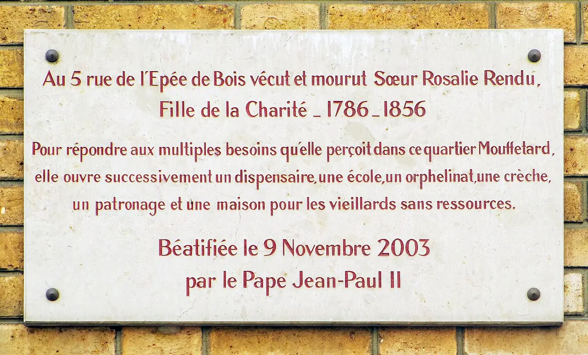 White marble plaque in French saying that Sister Rosalie Rendu, Daughter of Charity, lived and died at 5 rue de l'Épée-de-Bois, listing her works and her beatification on November 9, 2003