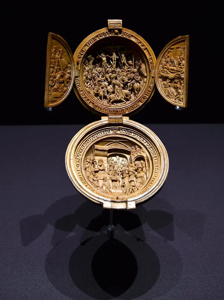 Opened boxwood prayer nut the size of a walnut, its hinged halves and side wings carved with crowded miniature scenes of the Passion of Christ