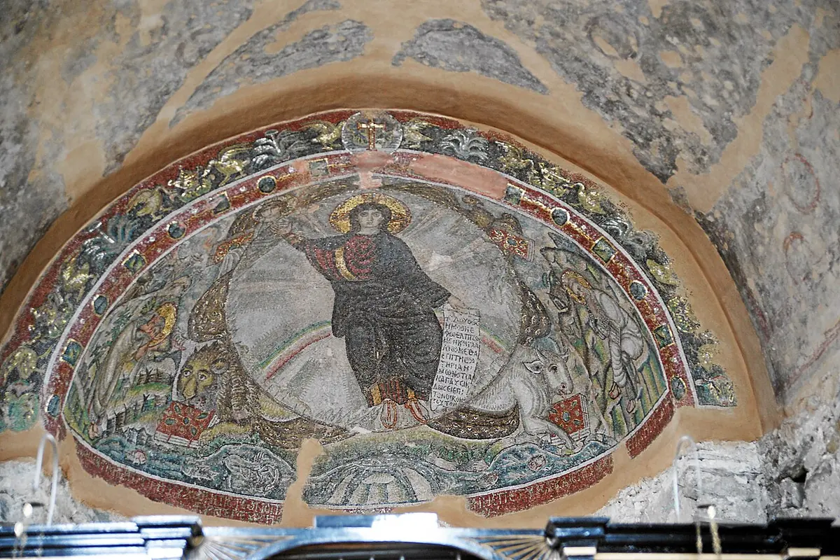 Early Christian mosaic of a beardless Christ seated on a rainbow in a circle of light, with winged creatures at the four corners