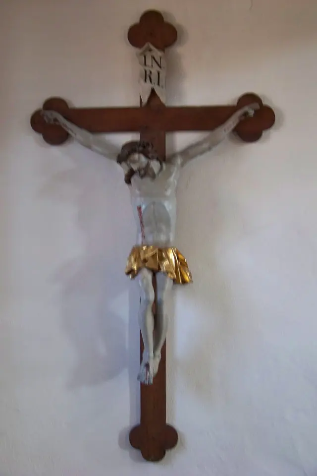 Wooden wall crucifix with a pale carved figure of Christ in a gilded loincloth and a small sign reading INRI above his head