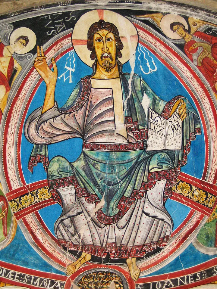 Pintura mural románica de Cristo sentado en majestad dentro de una mandorla, con túnica blanca y manto azul, que bendice con una mano y sostiene un libro abierto con la otra, sobre fondo de franjas de colores