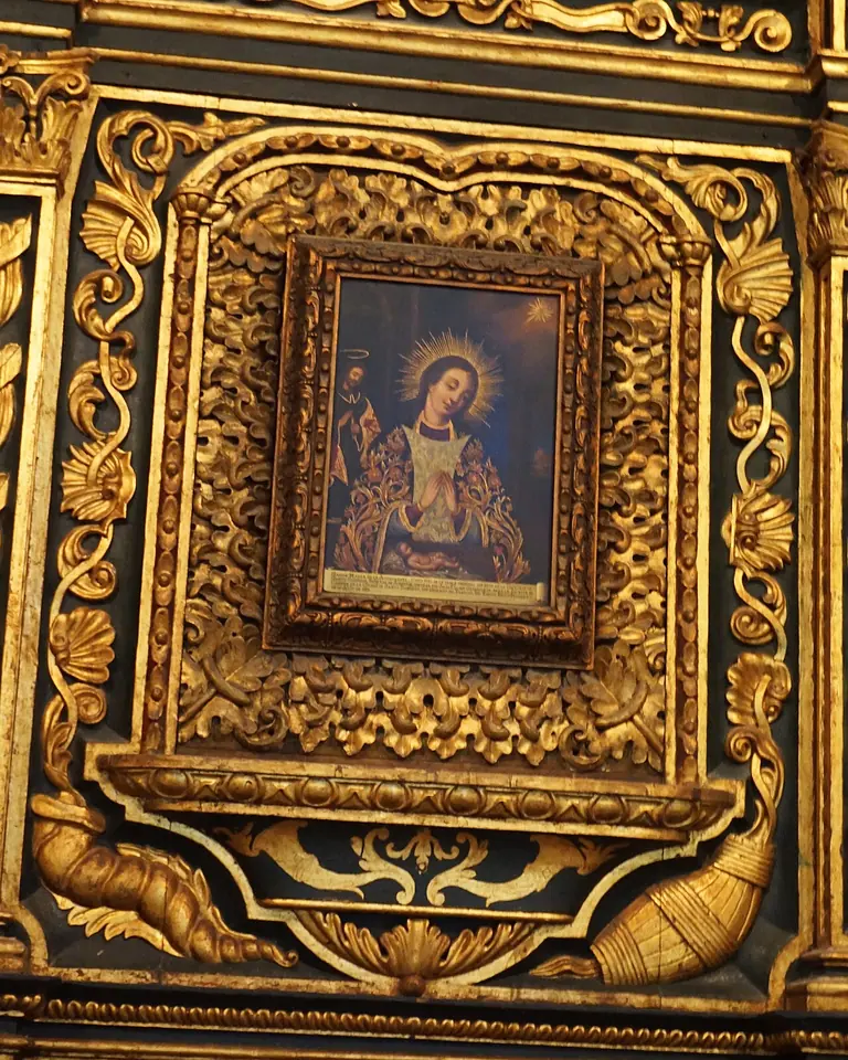 Pequeña pintura de la Virgen de la Altagracia dentro de un gran marco barroco de madera tallada y dorada, en una capilla de la catedral de Santo Domingo