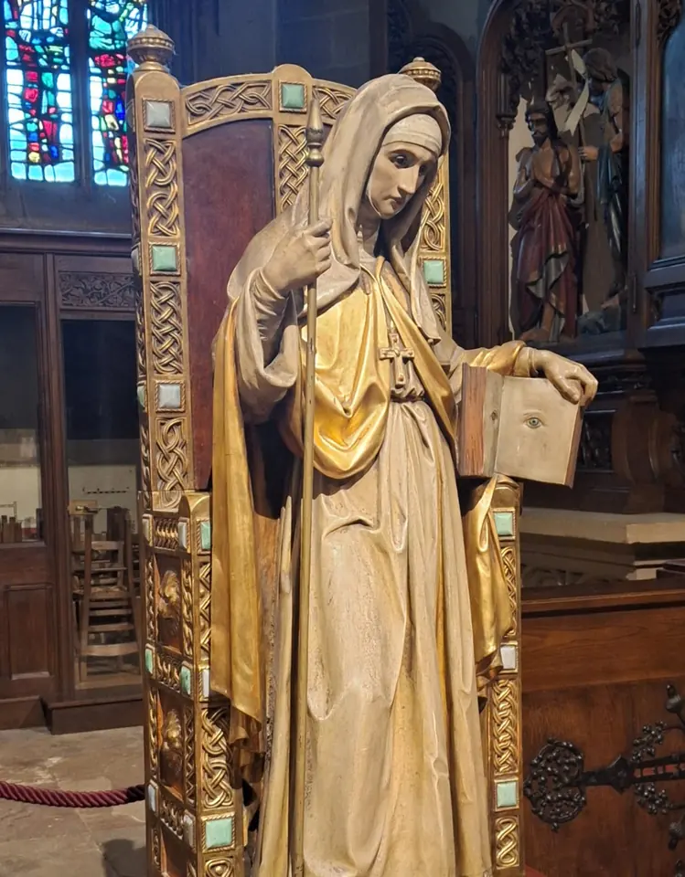 Gilded wooden statue of St. Odile as a veiled abbess holding a crosier and an open book with two eyes painted on it