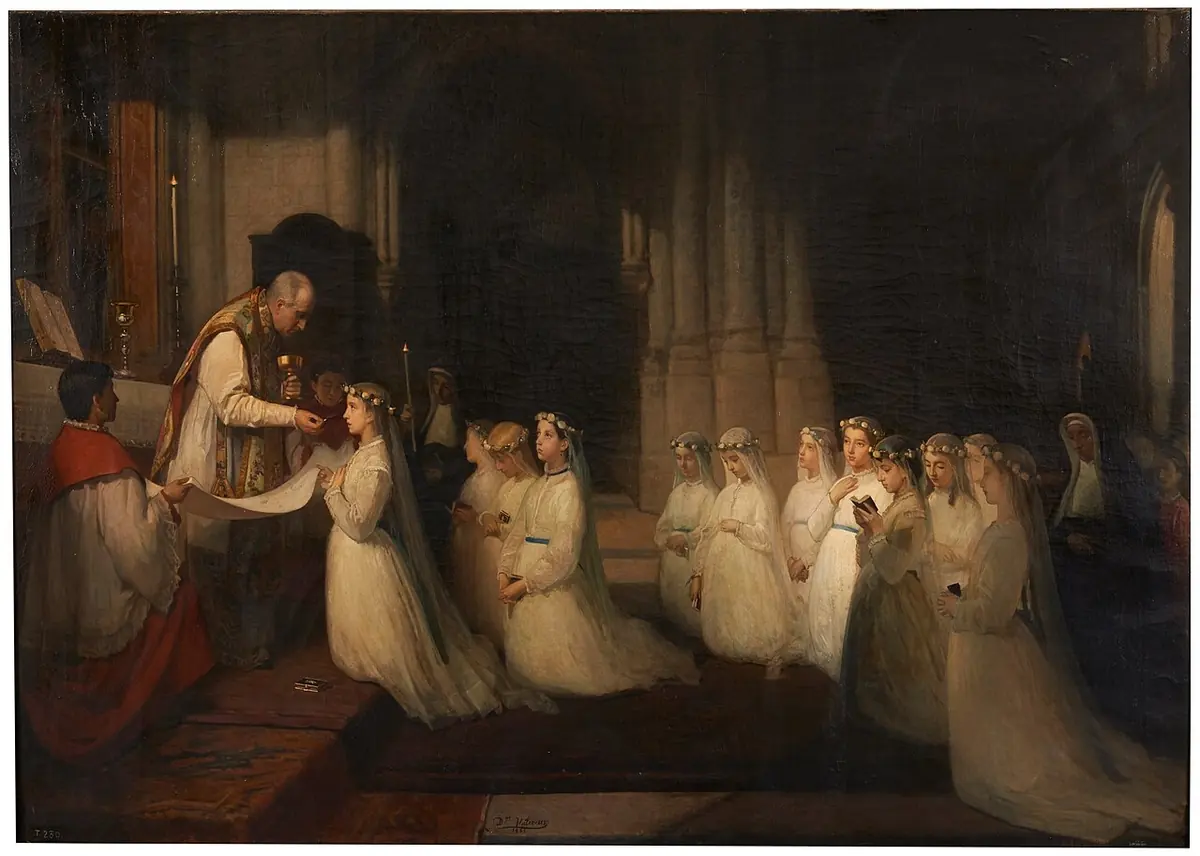 In a dark Gothic church, a priest gives Communion to a girl in a white veil kneeling at the altar while a long row of other girls in white kneel behind her