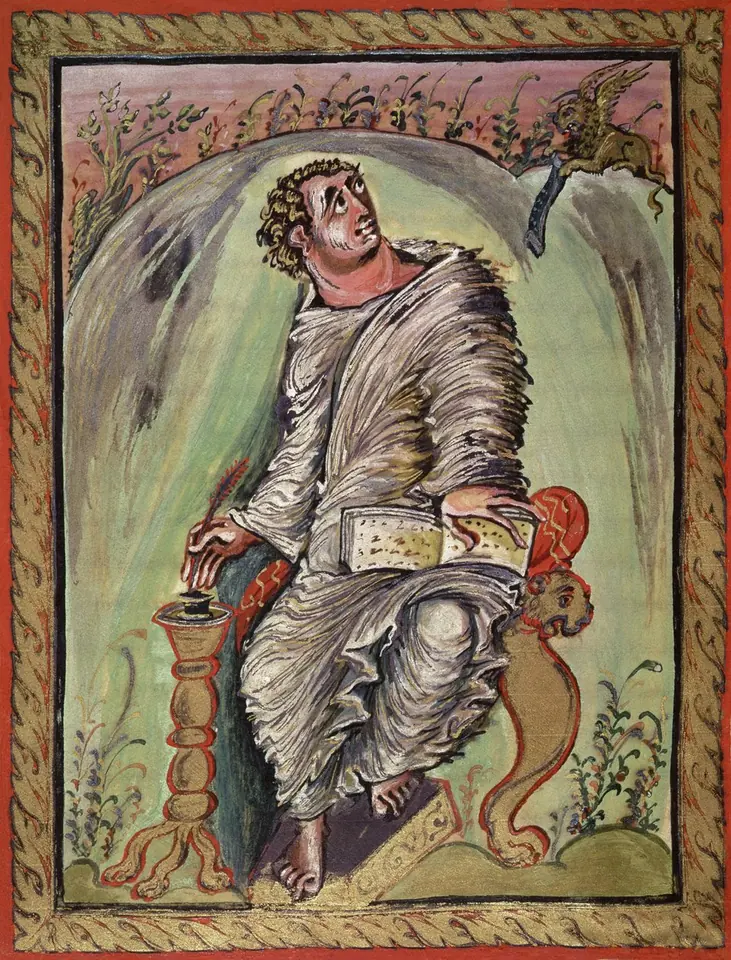 Carolingian manuscript painting of St. Mark in swirling robes seated on a bench writing in a book on a lectern, a small winged lion with a scroll in the upper corner