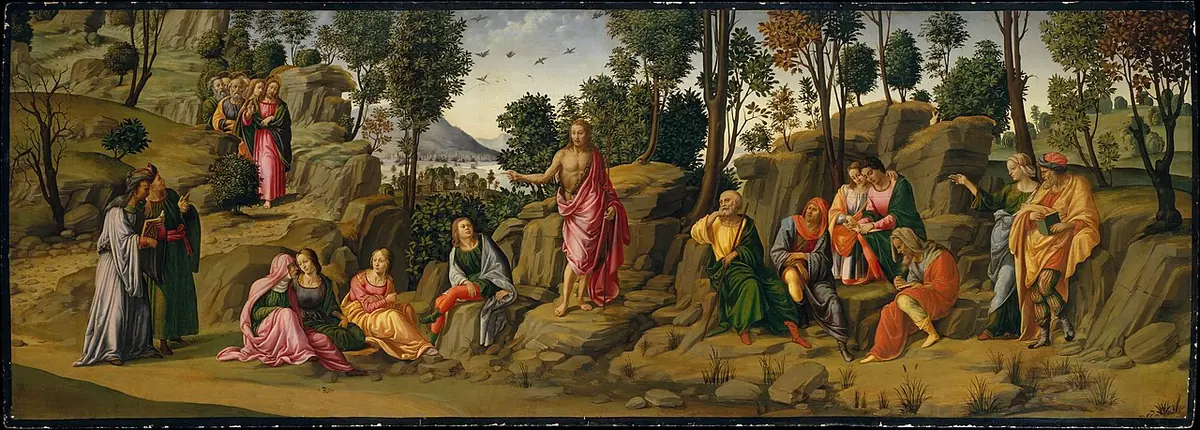 Long narrow Renaissance panel of a rocky landscape in which John the Baptist stands at the center pointing, surrounded by seated and standing listeners, with smaller scenes of his life on either side