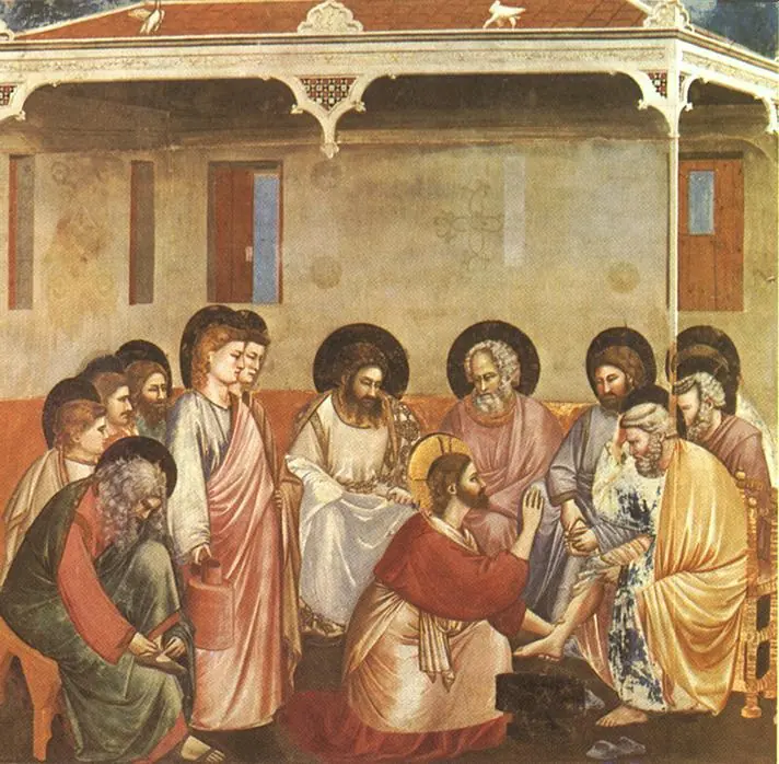 Fresco de Cristo arrodillado ante Pedro con una jofaina, mientras los apóstoles con aureola esperan sentados en un banco en una sala sencilla