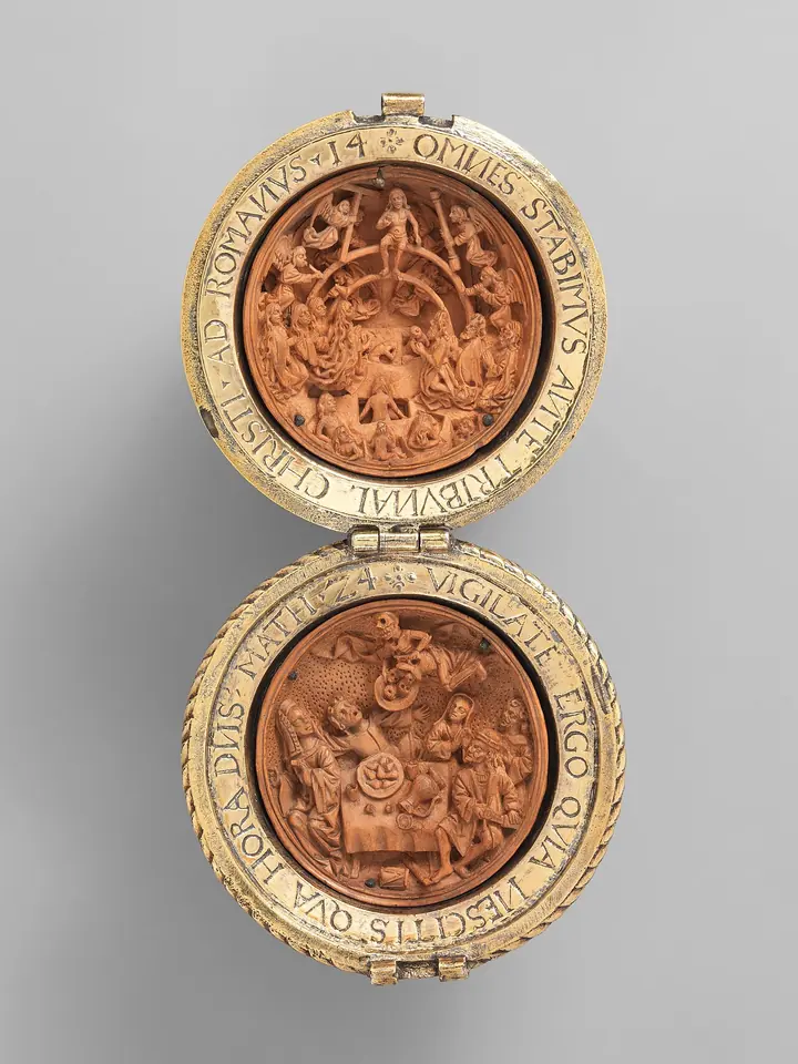 A round boxwood bead opened on a hinge into two halves, each carved inside with tiny crowded figures and ringed with a Latin inscription