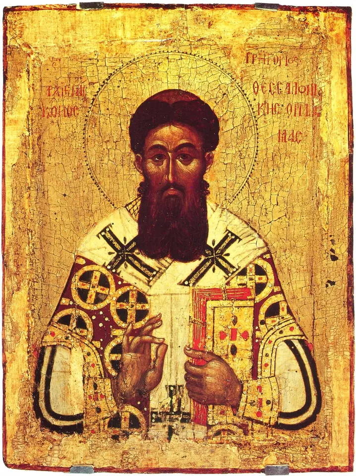 Byzantine icon of a dark-bearded bishop in a white vestment patterned with black crosses, holding a jeweled Gospel book and blessing
