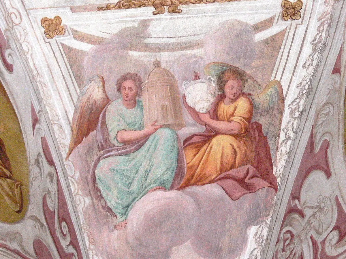 Ceiling fresco of two angels in pink and green robes on clouds holding up a small golden church building