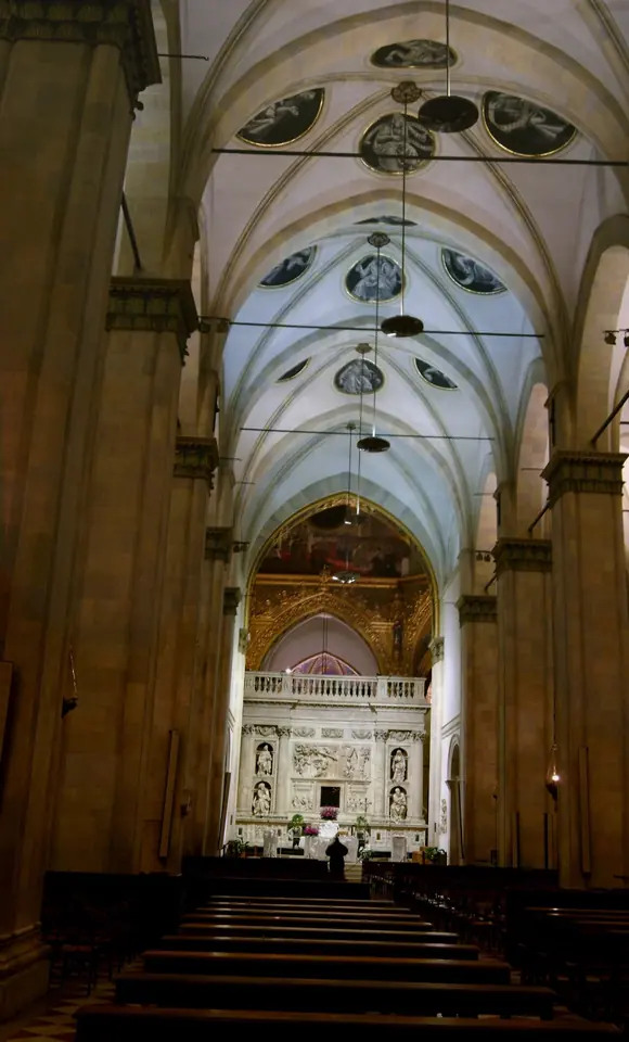 Long Gothic nave with pointed arches and painted vaults leading to the marble screen around the Holy House at the crossing