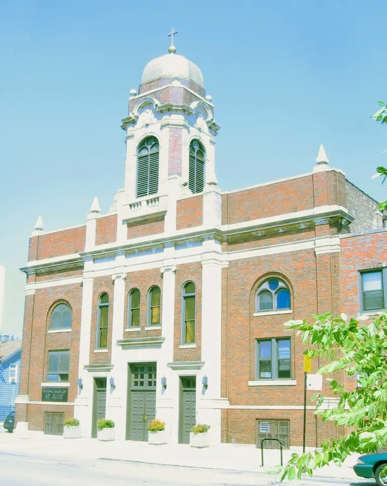 Brick church with a white bell tower and small dome on a sunny street corner in South Chicago