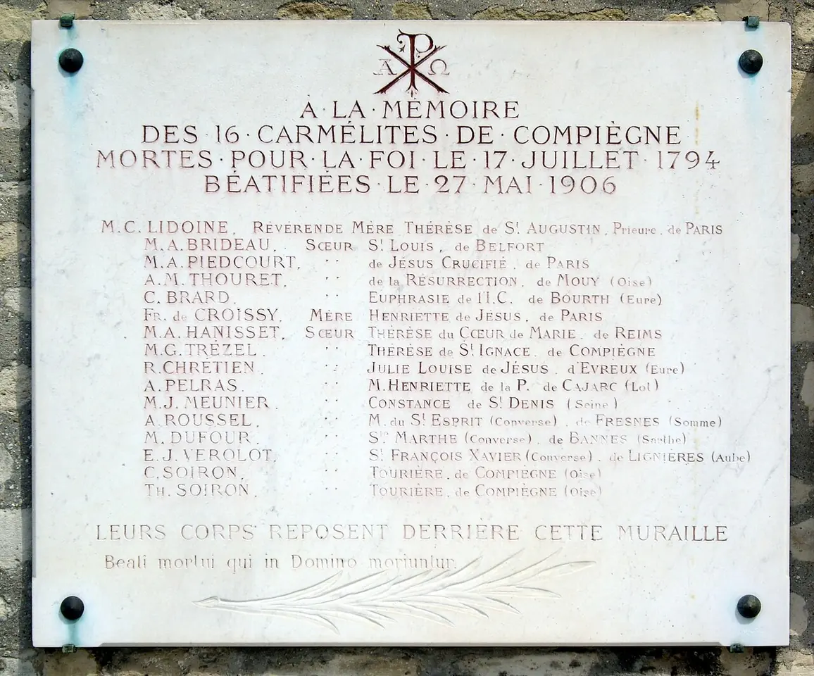 White marble plaque with a Chi-Rho at the top listing the names of the sixteen Carmelites of Compiègne who died for the faith on July 17, 1794