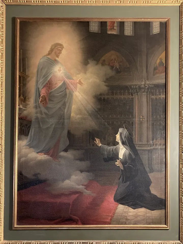Christ in white and red robes appears on clouds in a church choir, showing his glowing heart to a kneeling nun in a black habit