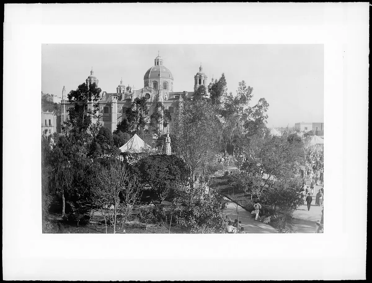 Fotografía en blanco y negro, hacia 1900, de la antigua basílica de Guadalupe, con su cúpula y sus torres sobre los árboles