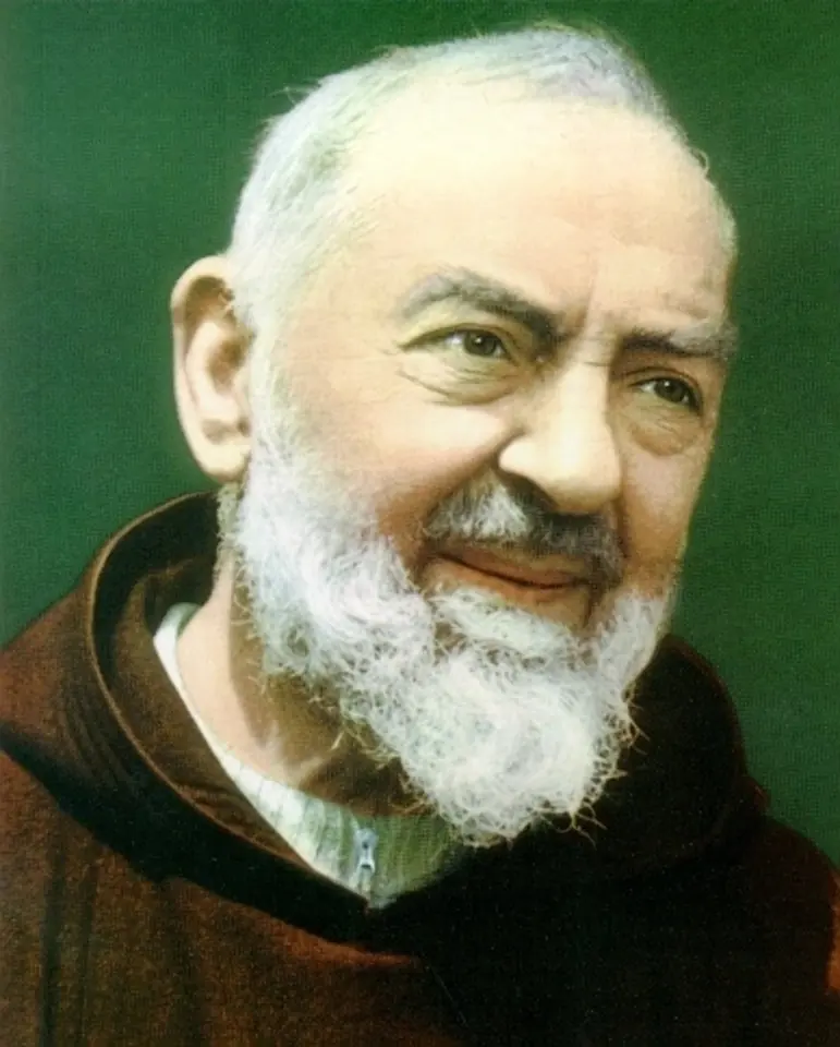 Color photograph of Padre Pio as a smiling older friar with a white beard, in a brown Capuchin habit, against a green background