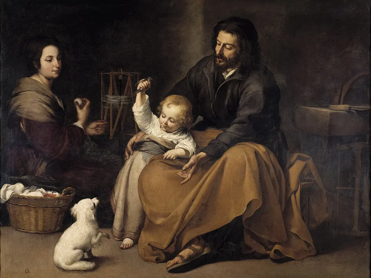 St. Joseph sits in a humble room holding the toddler Jesus on his knee as the child lifts a little bird out of reach of a small white dog, while Mary pauses at her spinning