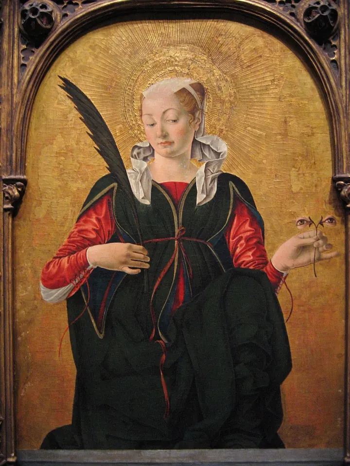 St. Lucy in a dark green gown and red sleeves holds a martyr's palm and a small stem bearing a pair of eyes, against a gold background