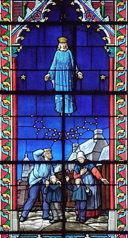 Stained-glass window showing Our Lady in a blue gown sprinkled with gold stars appearing in the night sky above a village, as a family with two boys looks up at her