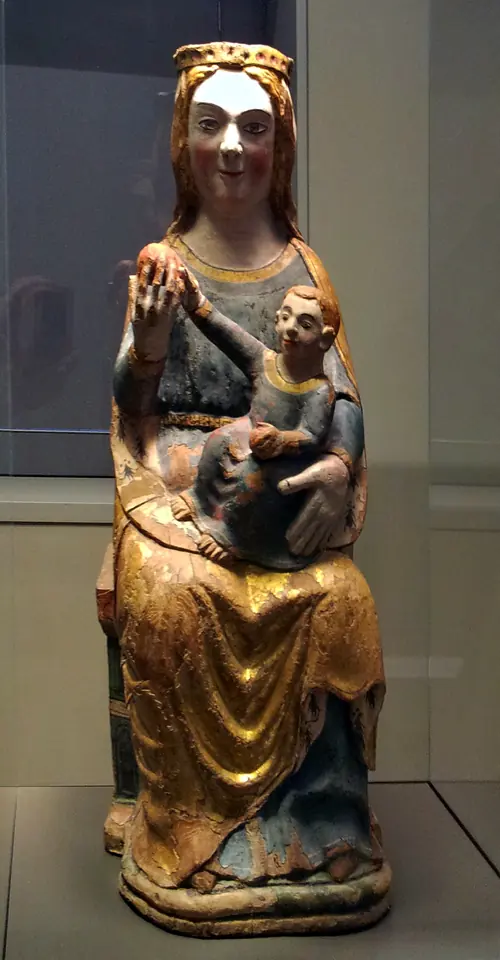 A painted medieval wooden statue of the crowned Virgin seated upright, holding the Child Jesus on her lap as on a throne