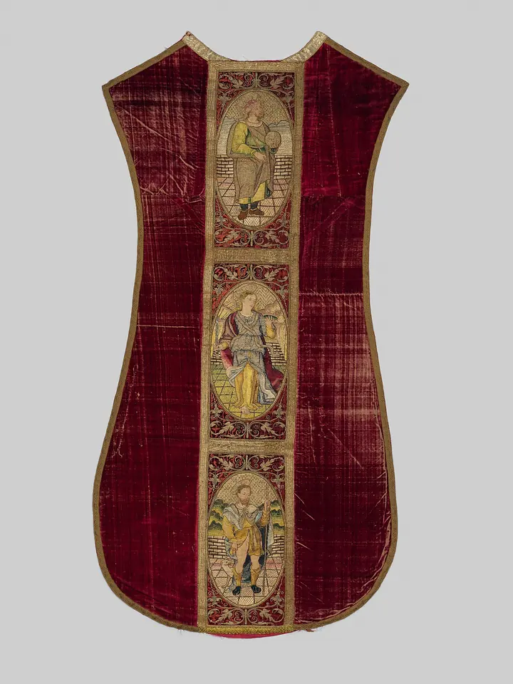 The back of a deep red velvet chasuble in the narrow fiddleback shape, with a central embroidered band showing three saints in oval frames