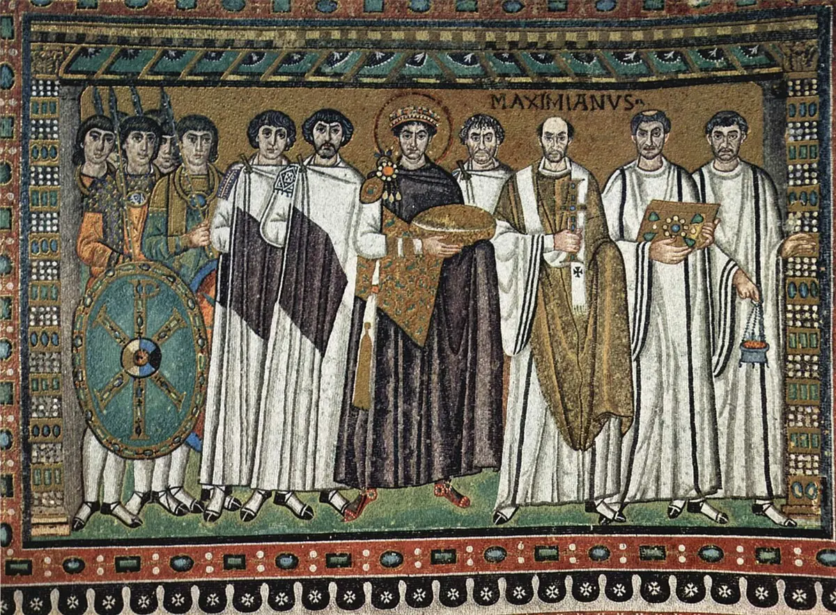 Byzantine mosaic on a gold ground of the emperor with a halo, flanked by soldiers and officials, and at right Archbishop Maximian in a gold chasuble with a white pallium, holding a jeweled cross, beside clergy in white tunics, one holding a book and one a censer