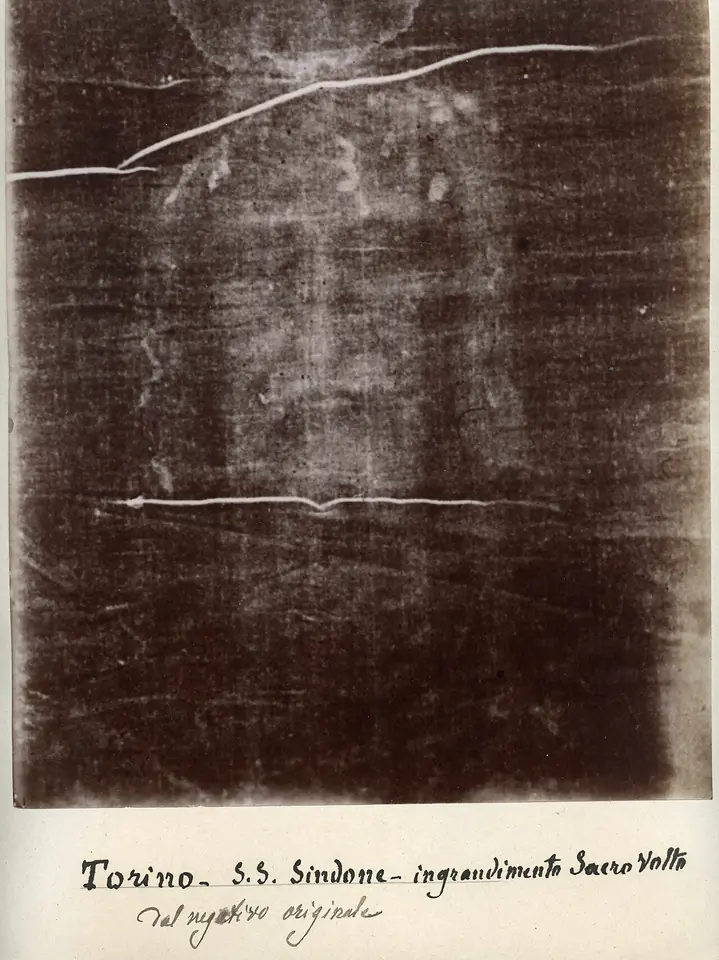 Sepia photograph of a cloth showing the faint face of a bearded man with long hair, labeled Torino S.S. Sindone in handwriting
