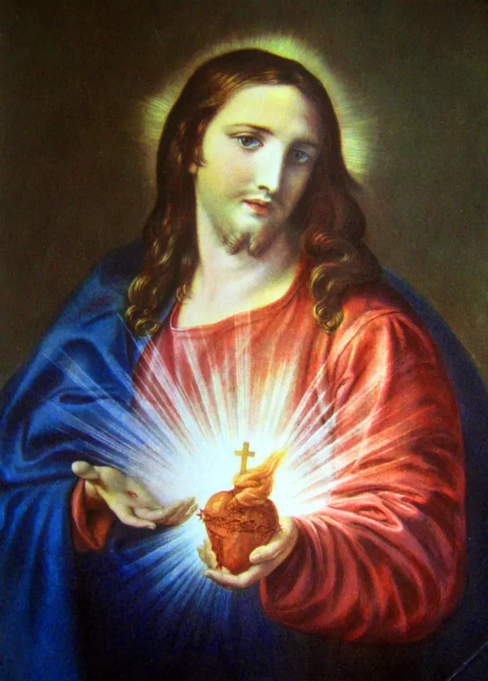 Painting of Jesus in a red robe and blue mantle holding out his glowing heart, topped with a small flame and cross and ringed with thorns, against a dark background