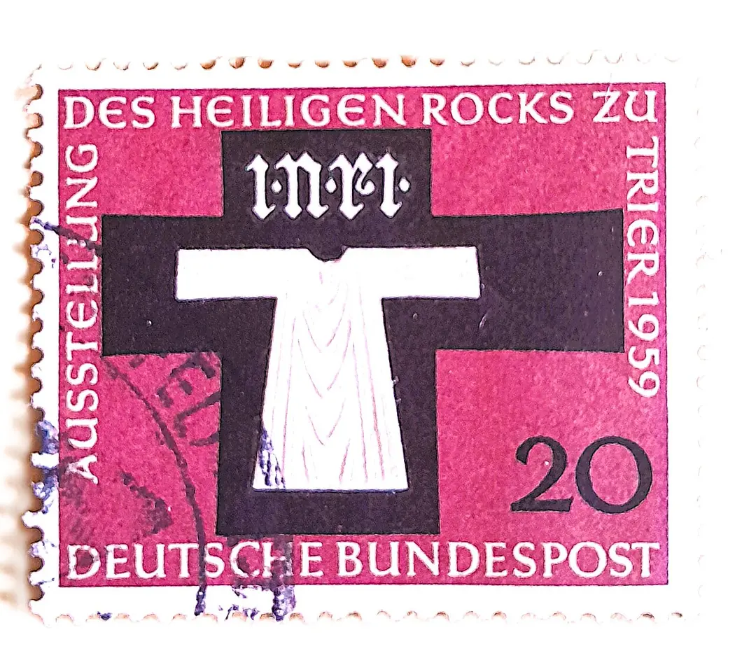 A magenta 20-pfennig postage stamp showing a white tunic on a dark cross under the letters INRI, with the words Ausstellung des Heiligen Rocks zu Trier 1959