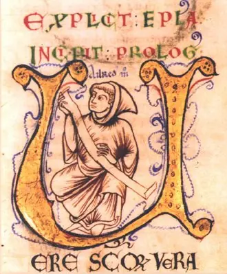 A large gold illuminated letter U enclosing a hooded monk seated and writing, with red and gold lettering above and below