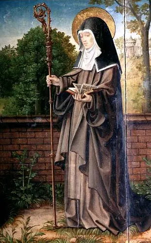 Painting of a haloed Poor Clare nun in a brown habit and black veil standing before a brick wall and trees, holding an abbess's crozier and an open book