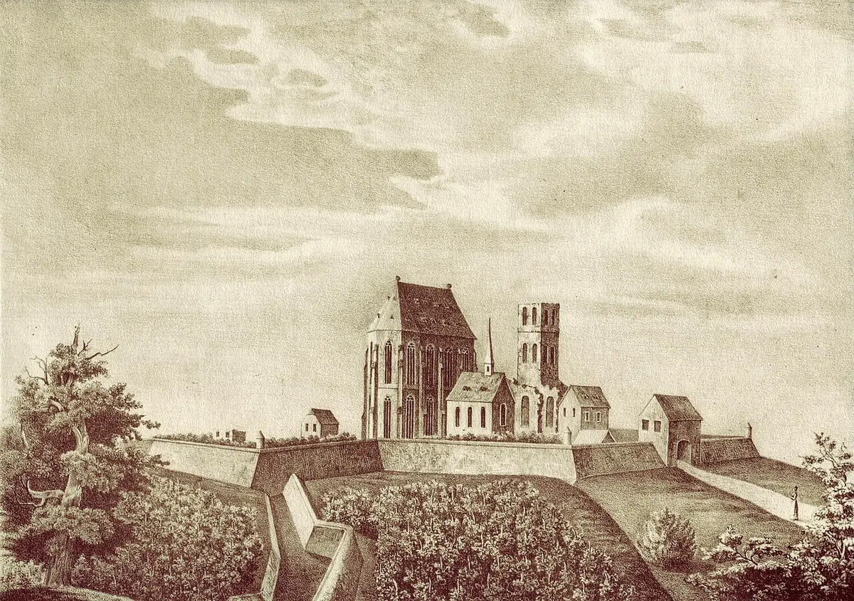 Sepia print of a large Gothic church with a tower and monastery buildings on a fortified hill above vineyards, under a wide cloudy sky