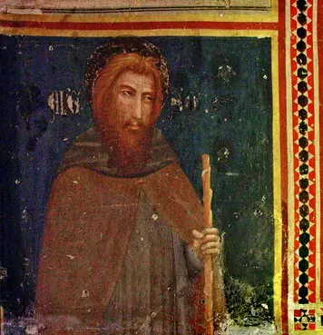 Mural gótico de San Alejo como un peregrino barbado con aureola, manto pardo y bastón, sobre un fondo azul oscuro