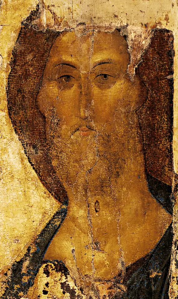 The worn face of Christ with a brown beard and calm, gentle eyes, on a weathered golden panel with large areas of paint lost