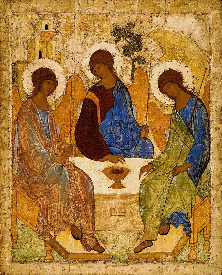 Icon of three winged angels with golden halos seated around a table with a chalice, the middle angel in deep red and blue, a house, a tree and a rock behind them
