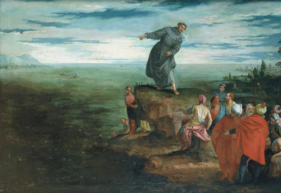 Painting of a friar standing on a rocky point at the sea's edge, stretching out his arms over the water, while a crowd in colorful robes watches from the shore