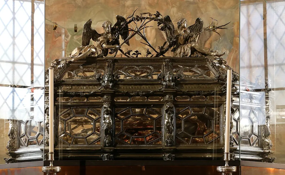 An ornate silver and rock-crystal urn with carved angels on its lid, resting on the altar of the Chapel of Sant'Aquilino