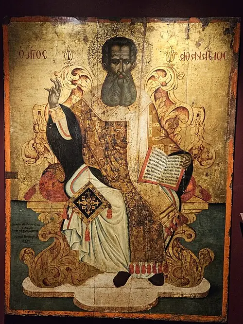 Post-Byzantine icon of a dark-bearded Athanasius enthroned in rich gold vestments, raising his hand in blessing and holding an open book